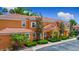 Lovely two-story condo with a Spanish tile roof, orange stucco, and mature landscaping at 2683 Corvette Ln, Kissimmee, FL 34746