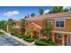 Charming condo with a Spanish tile roof, orange stucco, mature landscaping, and assigned parking at 2683 Corvette Ln, Kissimmee, FL 34746