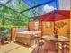 Screened patio featuring a hot tub, dining area, with an umbrella at 2683 Corvette Ln, Kissimmee, FL 34746