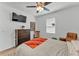This cozy bedroom features a dark wood dresser, ceiling fan and wall-mounted television at 280 Pershing St, Bartow, FL 33830