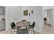 Dining area with a table and four chairs adjacent to the kitchen and hallway access to bedrooms at 280 Pershing St, Bartow, FL 33830