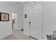 Clean and bright hallway featuring neutral tile flooring, white walls, and a white front door at 280 Pershing St, Bartow, FL 33830