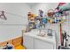Functional laundry room with shelving, laundry supplies and a side-by-side washer and dryer at 280 Pershing St, Bartow, FL 33830