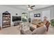 Comfortable living room with tile flooring, neutral-toned furniture, a ceiling fan, and a sliding glass door at 280 Pershing St, Bartow, FL 33830
