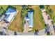 An aerial view of a charming home with a blue metal roof, lush landscaping, and brick-paved driveway at 3016 Wood Duck Dr, Polk City, FL 33868