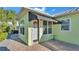 Light green home's entryway featuring a black striped awning and brick paved pathway at 3016 Wood Duck Dr, Polk City, FL 33868