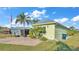 View of the side of a light green home with palm trees and trailer parked alongside the brick driveway at 3016 Wood Duck Dr, Polk City, FL 33868