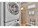 Modern laundry room featuring stackable washer and dryer units with a tile shower at 3016 Wood Duck Dr, Polk City, FL 33868