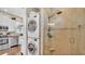 Modern laundry room featuring stackable washer and dryer units with a tile shower at 3016 Wood Duck Dr, Polk City, FL 33868