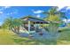 Enclosed Florida room with an outdoor entertaining space, manicured landscaping, and seating at 3016 Wood Duck Dr, Polk City, FL 33868