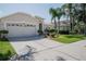 Inviting home features a two-car garage, and mature landscaping, creating a welcoming curb appeal at 3873 Hampton Hills Dr, Lakeland, FL 33810