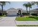 Charming single-story home features a well-manicured lawn, palm trees, and a two-car garage at 3873 Hampton Hills Dr, Lakeland, FL 33810