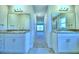 Modern bathroom with dual sinks, granite countertops, and elegant mirrors at 4019 Tullamore Ln, Auburndale, FL 33823