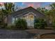 Charming single-story home with a quaint front porch and beautiful brick driveway at sunset at 402 W Patterson St, Lakeland, FL 33803