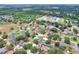 An aerial perspective of a residential neighborhood featuring houses with lush green yards and a swimming pool at 404 Willow Run, Lakeland, FL 33813