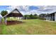 Backyard with a covered shelter and a large lawn near the pool and screen area at 404 Willow Run, Lakeland, FL 33813