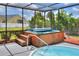 A close-up of a screened-in wooden hot tub and pool area with stairs at 404 Willow Run, Lakeland, FL 33813