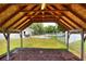 An interior view of a covered wood structure with wooden rafters and views of the surrounding yard at 404 Willow Run, Lakeland, FL 33813