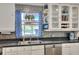 Well-lit kitchen featuring stainless steel appliances, tiled backsplash, and white cabinetry at 404 Willow Run, Lakeland, FL 33813