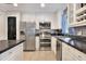 Modern kitchen showcasing stainless steel appliances, tile backsplash, and sleek black countertops at 404 Willow Run, Lakeland, FL 33813