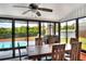 A sunroom has large windows overlooking a pool and a wooden dining table with chairs at 404 Willow Run, Lakeland, FL 33813