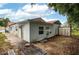 View of the backyard, with a metal table, shed, and house featuring light blue siding and a red metal roof at 409 San Jose Dr, Winter Haven, FL 33884