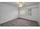 Bedroom featuring modern gray wood-look flooring and large window with blinds at 409 San Jose Dr, Winter Haven, FL 33884