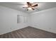 Bright bedroom featuring modern gray wood-look flooring and a window with blinds at 409 San Jose Dr, Winter Haven, FL 33884