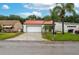 Charming single-story home with a well-manicured lawn, mature palm trees, and a red tiled roof at 409 San Jose Dr, Winter Haven, FL 33884