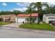 Charming single-story home with a well-manicured lawn, mature palm trees, and a red tiled roof at 409 San Jose Dr, Winter Haven, FL 33884
