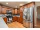 Well-equipped kitchen with stainless steel appliances, wood cabinets, and laminate floors at 409 San Jose Dr, Winter Haven, FL 33884