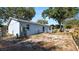 Home's backyard with an exposed foundation and mature trees at 417 Yolonda Ct, Lakeland, FL 33809