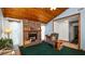 Cozy living room featuring a brick fireplace, wood ceiling, and ample natural light at 417 Yolonda Ct, Lakeland, FL 33809