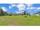 Large grassy backyard with neighboring homes, and a small landscaped area with a tree at 4582 Penkert Pl, Lakeland, FL 33811