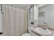 Well-lit bathroom with a single sink vanity, barn door cabinet, toilet, and shower with patterned curtain at 4582 Penkert Pl, Lakeland, FL 33811