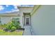 Front door to home, featuring a black front door, neutral paint and manicured landscaping at 4582 Penkert Pl, Lakeland, FL 33811