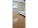 Bright bedroom featuring hardwood floors, a large window, and a minimalist aesthetic at 5211 Berkley Rd, Auburndale, FL 33823