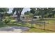View of home and detached garage from fenced yard, highlighting a spacious lot with mature trees at 5211 Berkley Rd, Auburndale, FL 33823