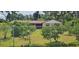 Ranch-style house with a charming tan exterior, well-maintained lawn, and mature trees around the property at 5211 Berkley Rd, Auburndale, FL 33823