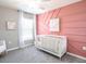 Cozy bedroom with a unique accent wall, white crib, and soft natural light creates a calming space at 5432 Se 127Th Ln, Belleview, FL 34420