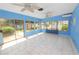Light-filled Florida room with tile flooring, ceiling fans, and sliding glass doors to the backyard at 5733 Oakwood Knoll Dr, Lakeland, FL 33811