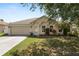 Charming single-story home with a well-maintained lawn, mature trees, and an attached two-car garage at 5733 Oakwood Knoll Dr, Lakeland, FL 33811