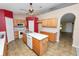 Well-equipped kitchen featuring light wood cabinetry, an island, tile flooring, and modern appliances at 5733 Oakwood Knoll Dr, Lakeland, FL 33811