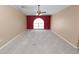 Large living room featuring neutral carpet, high ceilings, a ceiling fan, and a large window at 5733 Oakwood Knoll Dr, Lakeland, FL 33811