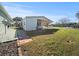 Single-story home with a covered patio area and a spacious, well-manicured backyard under a clear blue sky at 6087 Southern Oaks Se Dr, Winter Haven, FL 33884