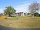 Single-story home featuring a covered carport, mature trees, and a well-maintained lawn, perfect for outdoor enjoyment at 6087 Southern Oaks Se Dr, Winter Haven, FL 33884