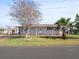 Charming single-story home featuring mature trees, a covered carport, and a well-manicured lawn on a sunny day at 6087 Southern Oaks Se Dr, Winter Haven, FL 33884