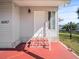 Welcoming front entrance with red brick steps and a white door, featuring a well-maintained exterior and charming details at 6087 Southern Oaks Se Dr, Winter Haven, FL 33884