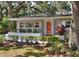 Home with mature trees, a freshly landscaped front yard, and a welcoming orange front door at 618 W Oak Dr, Lakeland, FL 33803