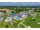 Aerial view of the clubhouse, pool, tennis courts, and manicured golf course at 6194 Sanderling Dr, Lakeland, FL 33809